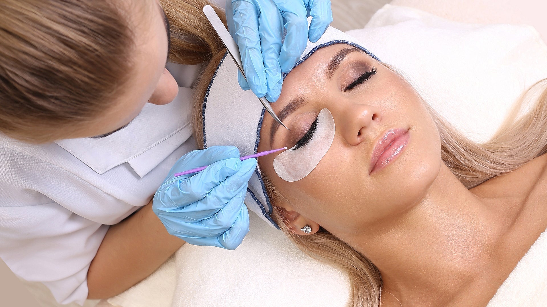technician is applying eyelash extensions